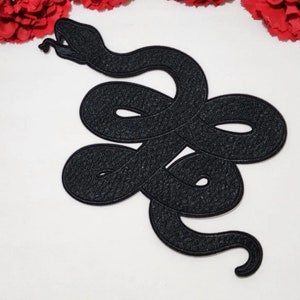 May include: Black embroidered snake patch. The snake is curled up with its head raised and its tongue sticking out.