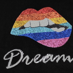May include: A black fabric patch with a rainbow sequined lips design and the word "Dream" in silver sequins.