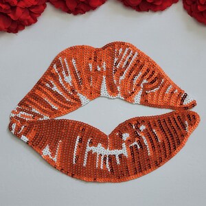 May include: Orange and white sequined lips applique patch.