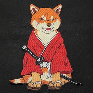 May include: An embroidered patch featuring a Shiba Inu dog with a scar over one eye, wearing a red kimono with a white sash and sandals. The dog is depicted in a seated position with a black and silver katana sword tucked into the sash at the waist.