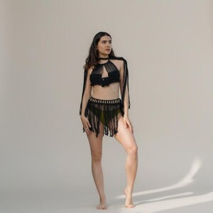 Black 3 piece macramé skirt and top set styled as a beach cover-up