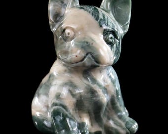 Può includere: Una statuetta in pietra lucida scolpita a forma di bulldog francese. La scultura presenta una superficie liscia e marmorizzata con motivi vorticosi di colore verde bosco intenso, crema e bianco su tutto il corpo del cane.