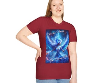 May include: A red t-shirt with a blue and purple phoenix graphic. The text "I am the Phoenix" and "The Phoenix is Me" is printed on the shirt.