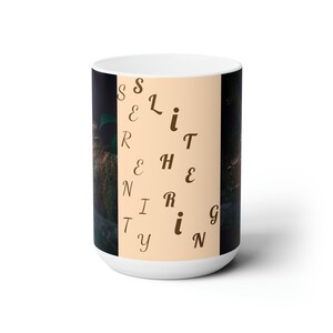 Op de afbeelding: Witte keramische mok met een bruine achtergrond en een ontwerp van het woord "Serenity" dat verticaal in bruine letters is gespeld.