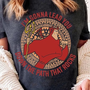 May include: A dark gray t-shirt with a red cartoon character holding a trident. The character is surrounded by a circular design with the text "I'm gonna lead you down the path that rocks".