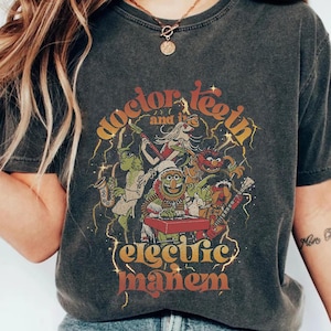 May include: A black t-shirt with a vintage-style graphic of Sesame Street characters playing music. The text on the shirt reads "Doctor Teeth and the Electric Mayhem".