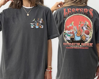 May include: A dark gray t-shirt with a cartoon illustration of a band of possums playing music. The text "Lester's Possum Park Possum Posse Jamboree" is printed on the shirt.