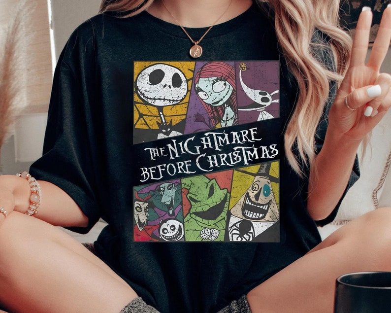 May include: Black t-shirt with a colorful graphic of characters from the movie "The Nightmare Before Christmas".