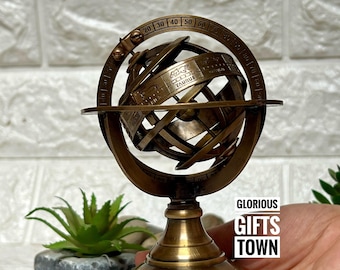 May include: A brass celestial globe with a wooden base. The globe is decorated with constellations and zodiac signs. The globe is on a stand with a wooden base. The globe is a decorative item and is not a functional tool.