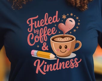 Könnte beinhalten: Marineblaues T-Shirt mit dem Text "Fueled by Coffee & Kindness". Das Design zeigt eine lächelnde Kaffeetasse mit herzförmigem Dampf, einen Bleistift und Sterne in einem rosa-braunen Farbschema.
