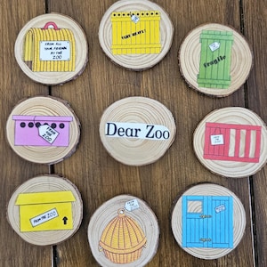 May include: A set of nine circular wood slices featuring illustrations from Dear Zoo. The centre slice reads Dear Zoo. Other slices show colourful animal crates and containers with tags labelled From the Zoo, Very Heavy, and Fragile.