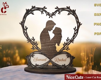 Può includere: Una decorazione in legno tagliata al laser raffigurante una coppia che si abbraccia all'interno di una cornice a forma di cuore. Il design include un simbolo infinito con i nomi "Samuel" e "Rachel". Il design include anche il testo "SVG, DXF, PNG, PDF" e "Nice Cuts - Laser Cut Ready Files."