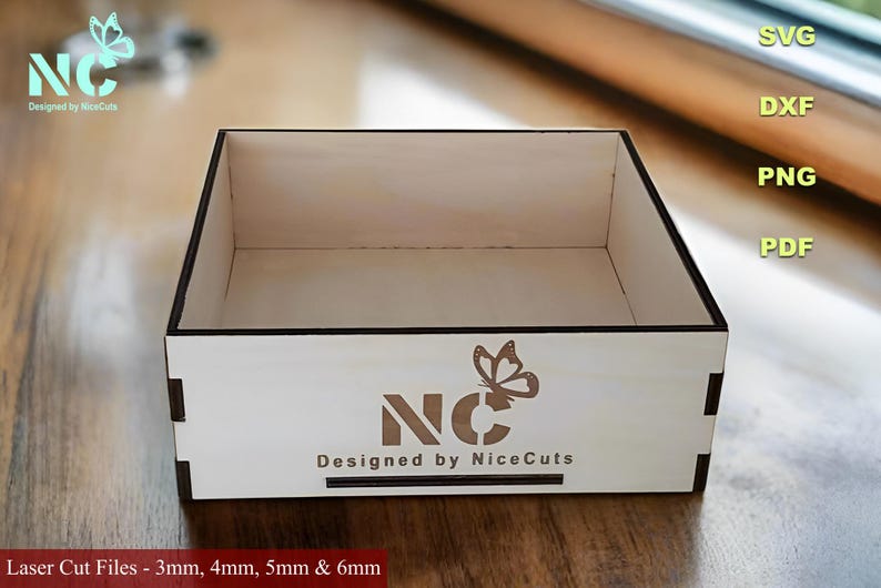 K&ouml;nnte beinhalten: Eine wei&szlig;e Holzkiste mit einem Schmetterlingsdesign und dem Text "NC Designed by NiceCuts". Die Box ist f&uuml;r den Laserschnitt geeignet und in den St&auml;rken 3 mm, 4 mm, 5 mm und 6 mm erh&auml;ltlich.