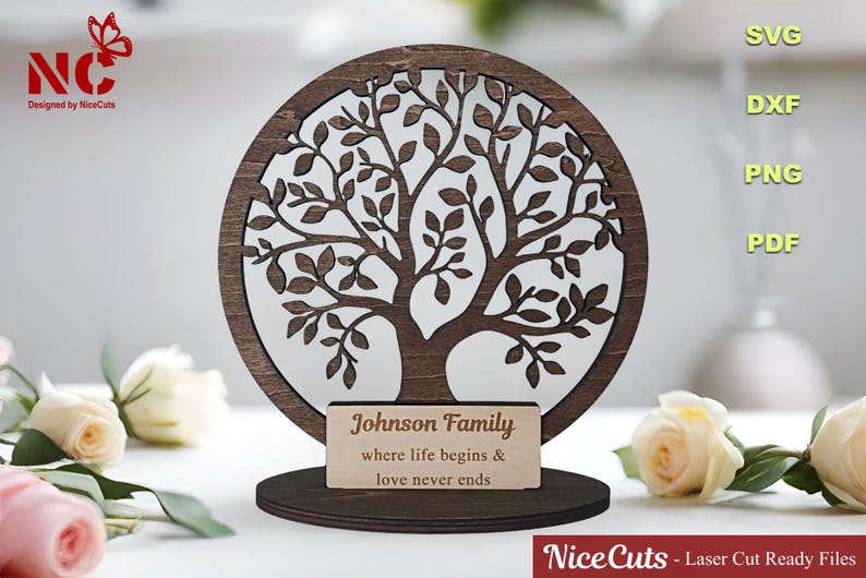 May include: A wooden cutout of a tree with a circular base. The tree has a brown stain and the text "Johnson Family where life begins & love never ends" is on a separate plaque.