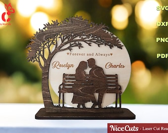 May include: A wooden laser-cut decorative piece featuring a couple on a bench under a tree. The names "Roselyn" and "Charles" are inscribed, along with the phrase "Forever and Always." The piece is on a rectangular base.
