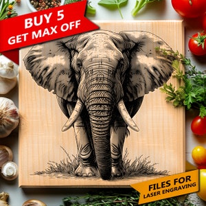 May include: A black and white line art illustration of an elephant's head and upper body on a light brown wooden cutting board. The elephant is facing forward with its trunk lowered. The text "FILES FOR LASER ENGRAVING" is in the lower right corner of the board.