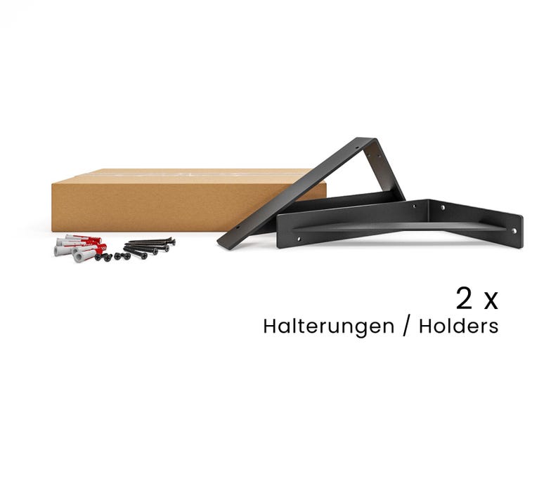 May include: Two black metal shelf brackets with screws in a brown cardboard box. The text "2x Halterungen / Holders" is printed below the brackets.