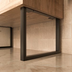 Op de afbeelding: Zwarte metalen tafelpoten met een rechthoekige vorm. De poten zijn bevestigd aan een houten tafelblad.