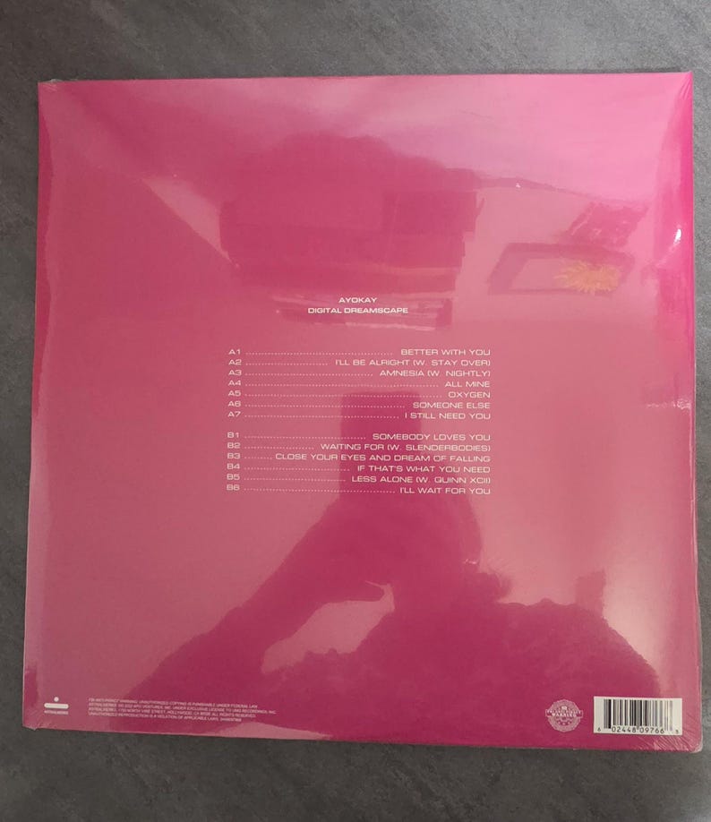 May include: A pink-covered vinyl record album, sealed in plastic. The album is titled "Digital Dreamscape" by Ayokay. The tracklist is printed in white, with song titles such as "Better With You" and "I'll Wait For You".