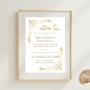 Peut inclure: Impression encadrée avec calligraphie dorée et ornements décoratifs sur fond blanc. Le texte comprend des caractères arabes et des traductions en anglais, avec un symbole de croissant de lune. L'impression est dans un cadre en bois clair.