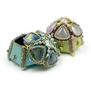 May include: Two small, intricately beaded boxes with lids. One box is teal with a labradorite stone design and the other is green with a clear stone design.