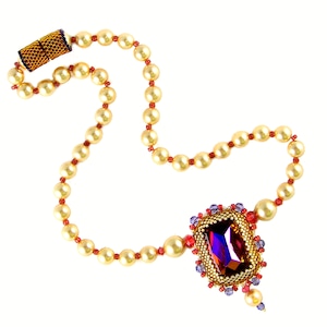 May include: A gold beaded necklace with a large, faceted, iridescent purple gemstone pendant. The pendant is surrounded by smaller red and gold beads.