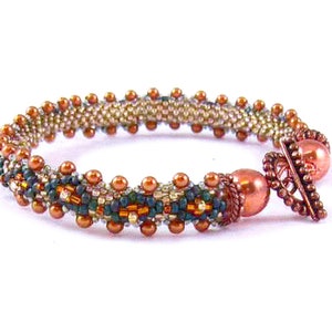May include: A beaded bracelet with a copper clasp. The bracelet is made with brown, beige, and green beads.