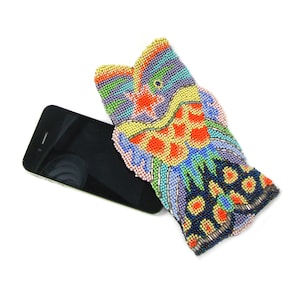 Puede incluir: Una funda de teléfono de cuentas coloridas con un diseño de pez. La funda está hecha de pequeñas cuentas coloridas y presenta una variedad de colores, incluyendo azul, verde, amarillo, naranja y rojo.