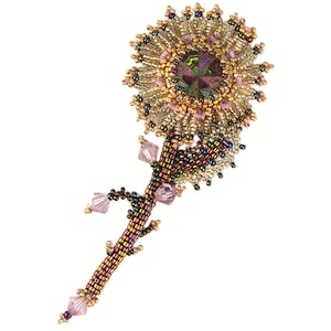 Könnte beinhalten: Eine Brosche in Form einer Blume aus Perlen mit einem großen, schillernden grünen Zentrum, umgeben von kleineren rosa und goldenen Perlen. Der Stiel besteht aus braunen und goldenen Perlen mit rosa Kristall-Akzenten.