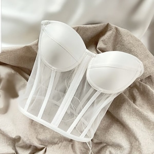 May include: White mesh corset top with boning and a sweetheart neckline.