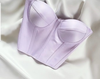 May include: A lavender strapless corset with boning and a satin finish.