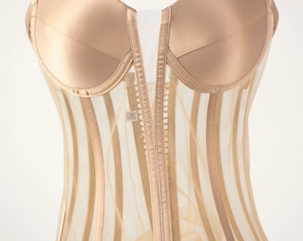 May include: A nude-colored strapless corset with a sheer mesh bodice and satin cups. The corset has vertical stripes and a front zipper closure.