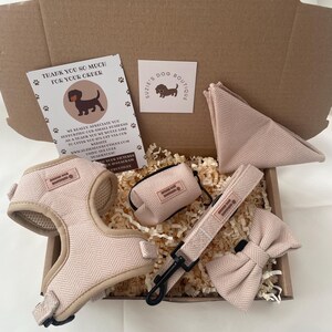 Puede incluir: Un conjunto de arn&eacute;s para perro en color beige con patr&oacute;n de espiga, que incluye arn&eacute;s, correa, pajarita, dispensador de bolsas y pa&ntilde;uelo triangular. Incluye una tarjeta de agradecimiento y una tarjeta con el logo de Suzie's Dog Boutique.