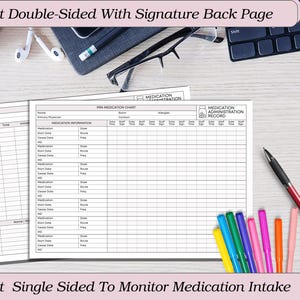 May include: A medication chart with the text "Print Double-Sided With Signature Back Page" and "Print Single Sided To Monitor Medication Intake". The chart is white with black lines and includes sections for medication information and administration records. A pen and colorful markers are also visible.