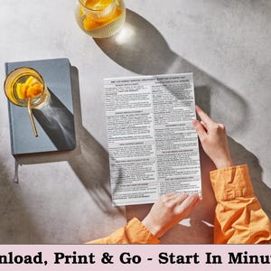 May include: A top-down shot shows a person holding a printed document with text. A blue notebook and a glass of orange-infused beverage with a gold straw are on the left. The text at the bottom reads: Download, Print & Go - Start In Minutes.