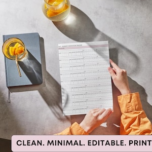 May include: A medication tracker with a pink header is held by a person wearing an orange shirt. A blue notebook and a glass of orange-infused water sit nearby. The text "CLEAN. MINIMAL. EDITABLE. PRINTABLE." is at the bottom.
