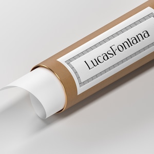 K&ouml;nnte beinhalten: Eine braune Pappr&ouml;hre mit goldener Einfassung und einem wei&szlig;en Etikett mit dem Text "LucasFontana" in einem schwarzen Zierrahmen.