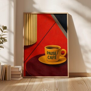May include: A framed art print featuring a yellow coffee cup on a matching saucer, centered on a dark circular surface. The cup displays the green text PAUSE/CAFÉ. The background is a bold red with geometric shapes in black and yellow stripes.