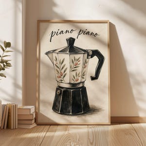May include: A framed wall art print featuring a black and white illustration of a moka pot coffee maker. The upper chamber is decorated with green olive branches and small orange olives. The text "piano piano" is written in black cursive above.