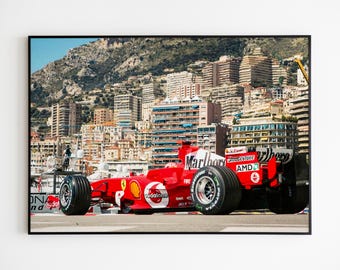 Könnte beinhalten: Ein roter Formel-1-Rennwagen mit den Worten "Marlboro", "AMD" und "Bridgestone" darauf. Das Auto fährt auf einer Strecke vor einer Skyline.
