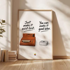 May include: A framed poster featuring a wooden Apple I computer replica on the left and a silver Mac Mini on the right. The text reads Just make it exist first. You can make it good later. A small rainbow Apple logo is centred at the bottom.