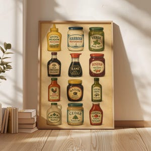 May include: A rectangular wall art print featuring a grid of twelve illustrated condiment jars and bottles with labels including Golden Meadow Mustard, Harbour Mayonnaise, Verde Basil Pesto, Old Orchard Balsamic, Kame Soy Sauce, Rosehip Preserve, Red Rooster Chilli, Mallow Yeast Extract, Tuscan Grove Olive Oil, Northwood Maple, Cedar Tahini, and Garden Ketchup.