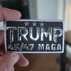 Donald Trump iron-on patch with MAGA and 45/47 black with silver lettering with white border.  Perfect gift for Trump fans