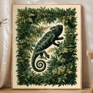 May include: A rectangular wall art print featuring a dark green chameleon with a curled tail positioned in the center. The chameleon is surrounded by a dense, rectangular border of detailed green leaves and foliage on a cream-colored background.
