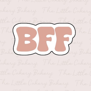 Puede incluir: Un cortador de galletas con la forma de las letras "BFF" en una fuente retro. Las letras son de color melocotón apagado con un contorno negro y un borde blanco. El fondo es de color rosa claro.