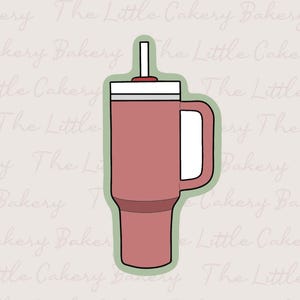 Può includere: Un bicchiere rosso con manico bianco e coperchio bianco con cannuccia. Il bicchiere è delineato in verde. Lo sfondo presenta le parole "The Little Cakery Bakery" in un motivo ripetuto.