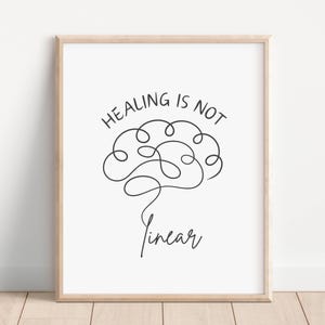 Puede incluir: Una impresión de arte de pared imprimible en blanco y negro con un cerebro dibujado en una línea continua. El texto "Healing is not linear" está escrito sobre el cerebro.