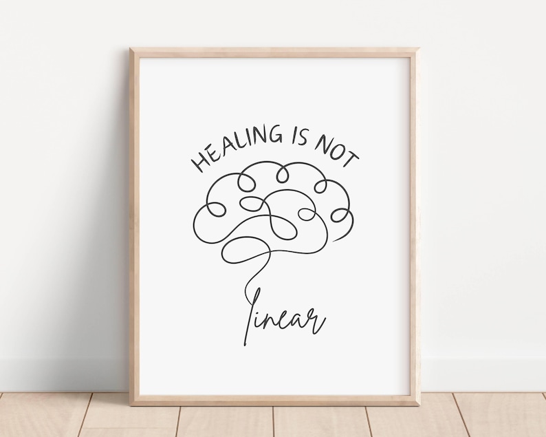 May include: A black and white printable wall art print with a brain drawn in a continuous line. The text "Healing is not linear" is written above the brain.