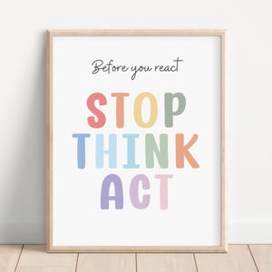 Puede incluir: Una impresión enmarcada con el texto "Before you react STOP THINK ACT" en colores arcoíris. Las letras están en una fuente redonda y juguetona.