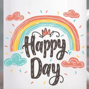Pode incluir: Caneca de cerâmica branca com um design de arco-íris colorido e as palavras "Happy Day" em uma fonte extravagante. A caneca tem uma alça e é decorada com pequenas nuvens. A caneca está em uma mesa de madeira.
